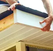 A person installing a panel on a ceiling with hands positioned for support.